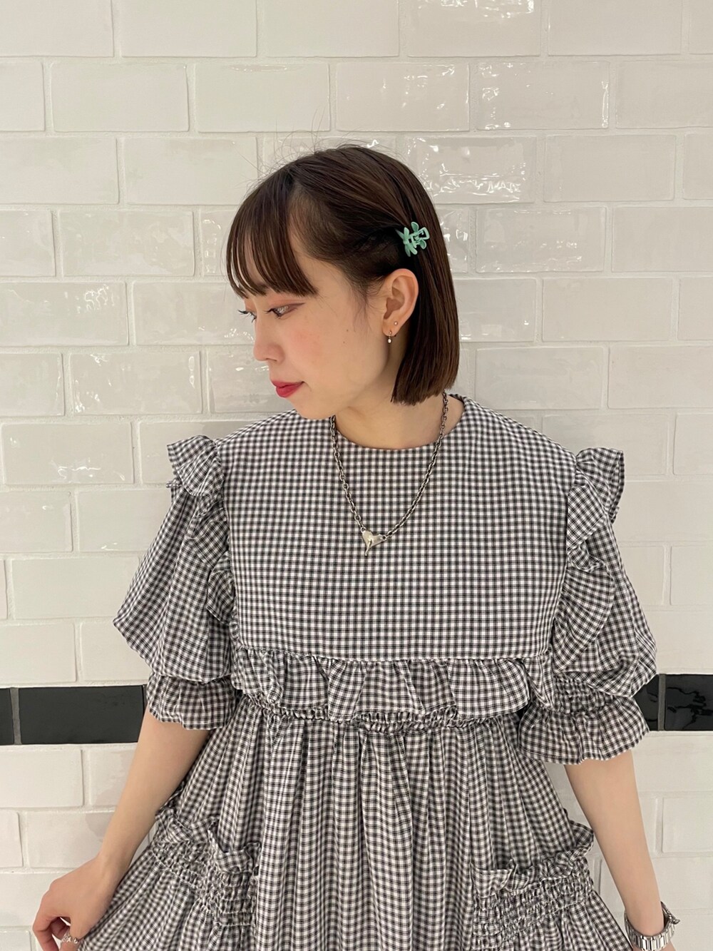 ホワイト系のワンピース、ブラック系のブーツを着用したレディースの春コーディネートの4枚目の写真