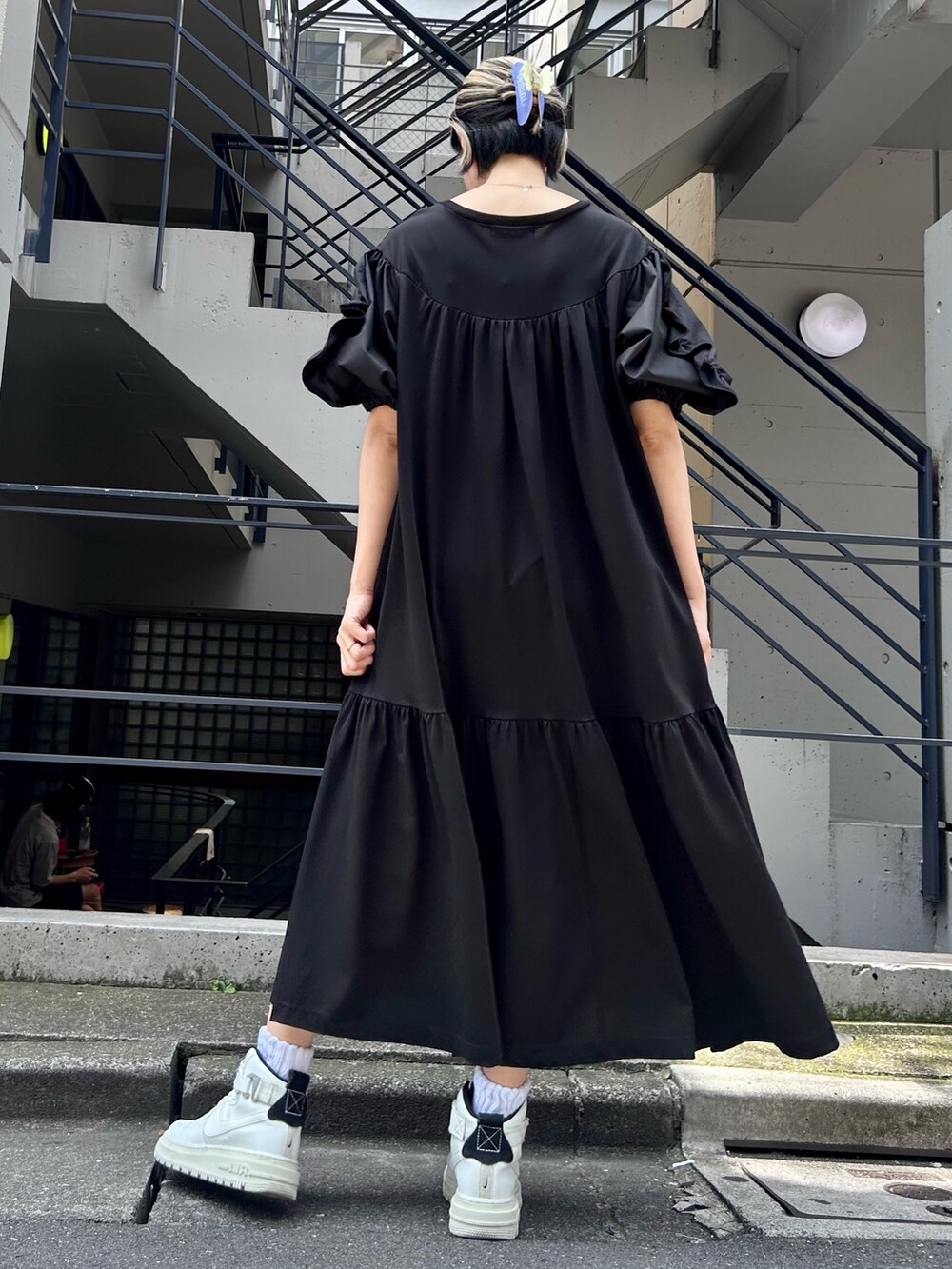 ブラック系のワンピース、ブラック系のショルダーバッグ、ホワイト系のシューズを着用したレディースの夏コーディネートの5枚目の写真