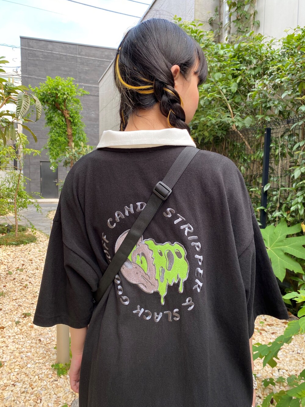 ブラック系のポロシャツ、ホワイト系のショルダーバッグを着用したレディースの夏コーディネートの5枚目の写真