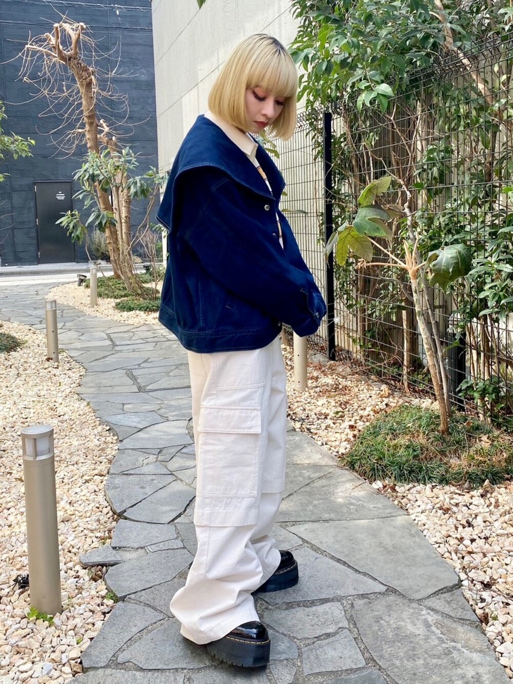 ホワイト系のカーゴパンツ、イエロー系のポロシャツ、ブルー系のデニムジャケットを着用したレディースの春コーディネートの3枚目の写真