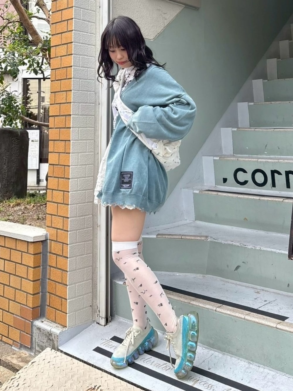 ホワイト系のTシャツ/カットソー、ブルー系のカーディガン/ボレロ、ホワイト系のスカートを着用したレディースの秋コーディネートの3枚目の写真