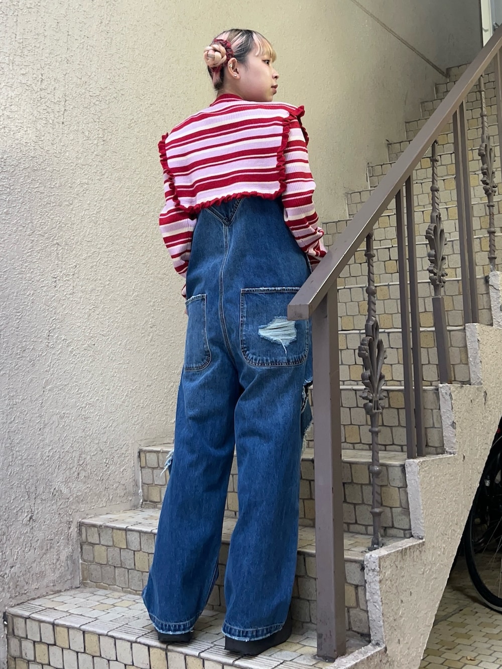 レッド系のニット/セーター、ブルー系のサロペット/オーバーオール、ホワイト系のその他アウターを着用したレディースの秋コーディネートの4枚目の写真