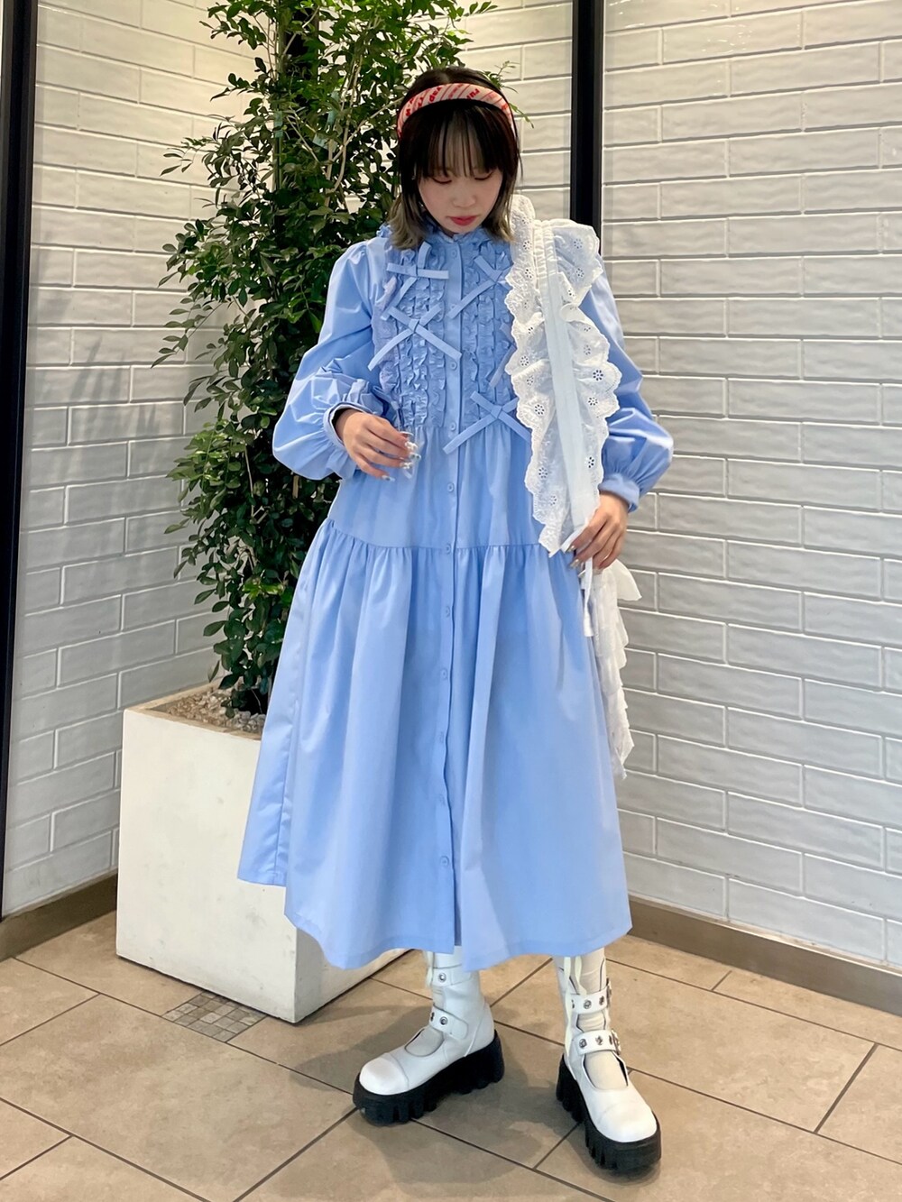 ブルー系のワンピース、ホワイト系のショルダーバッグ、ホワイト系のブーツを着用したレディースの冬コーディネートの2枚目の写真