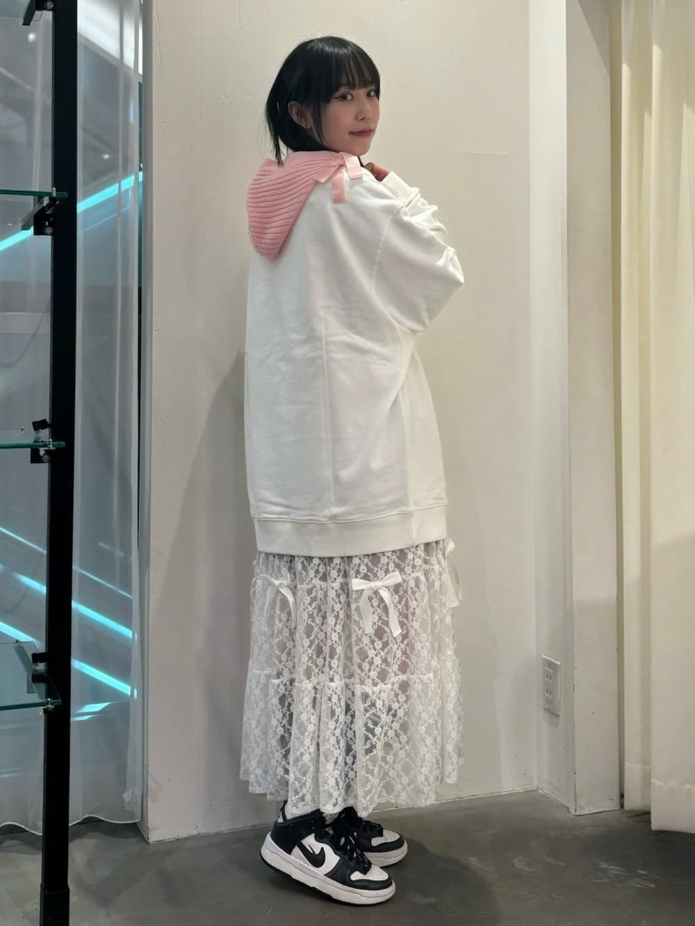 ホワイト系のシューズ、ホワイト系のスウェット、ピンク系のワンピースを着用したレディースの秋コーディネートの5枚目の写真