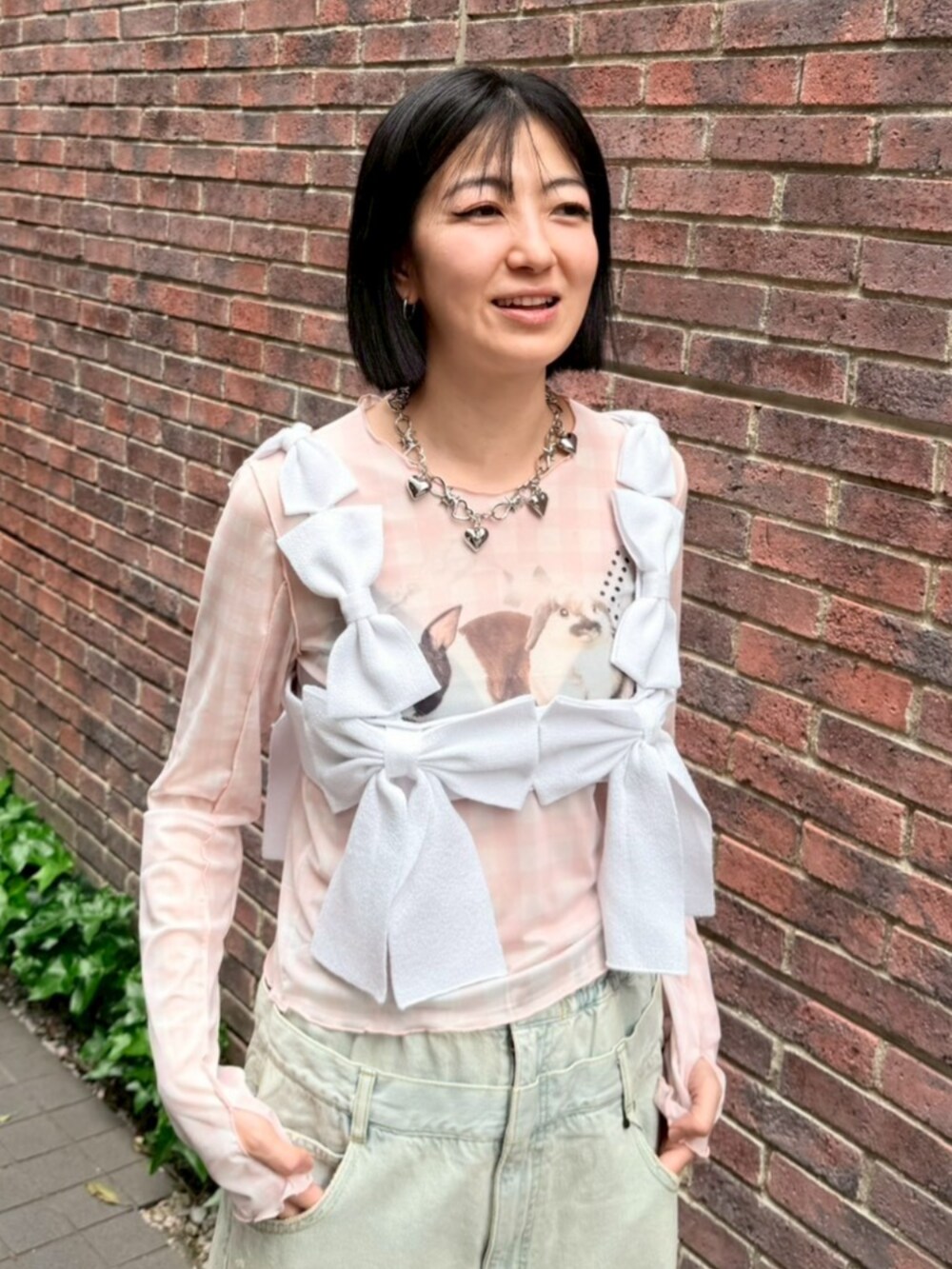 ブルー系のデニムパンツ、ホワイト系のその他トップス、ピンク系のTシャツ/カットソーを着用したレディースの春コーディネートの4枚目の写真
