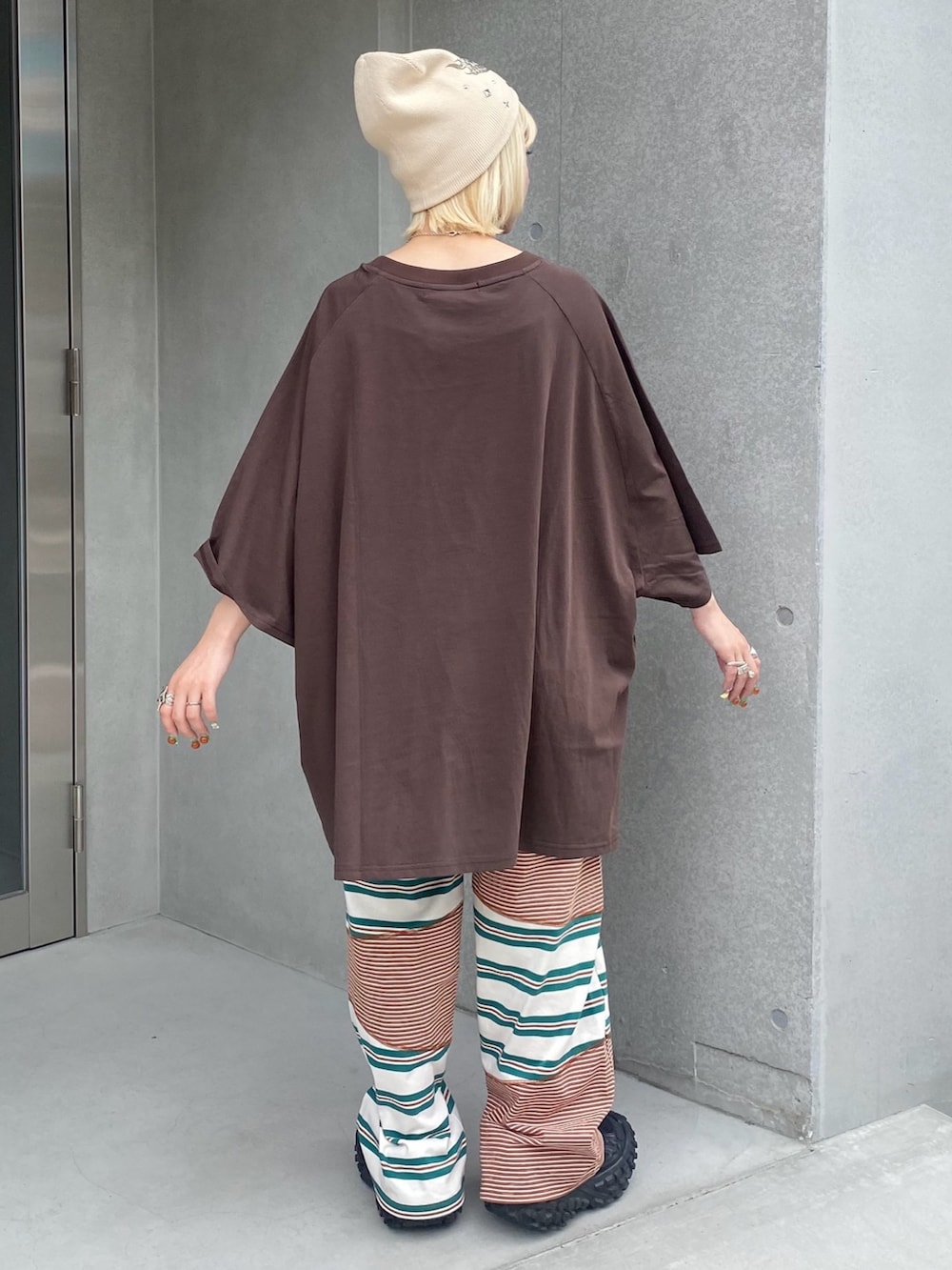 グリーン系のその他パンツ、ブラウン系のTシャツ/カットソー、ホワイト系のニットキャップ/ビーニーを着用したレディースの夏コーディネートの5枚目の写真