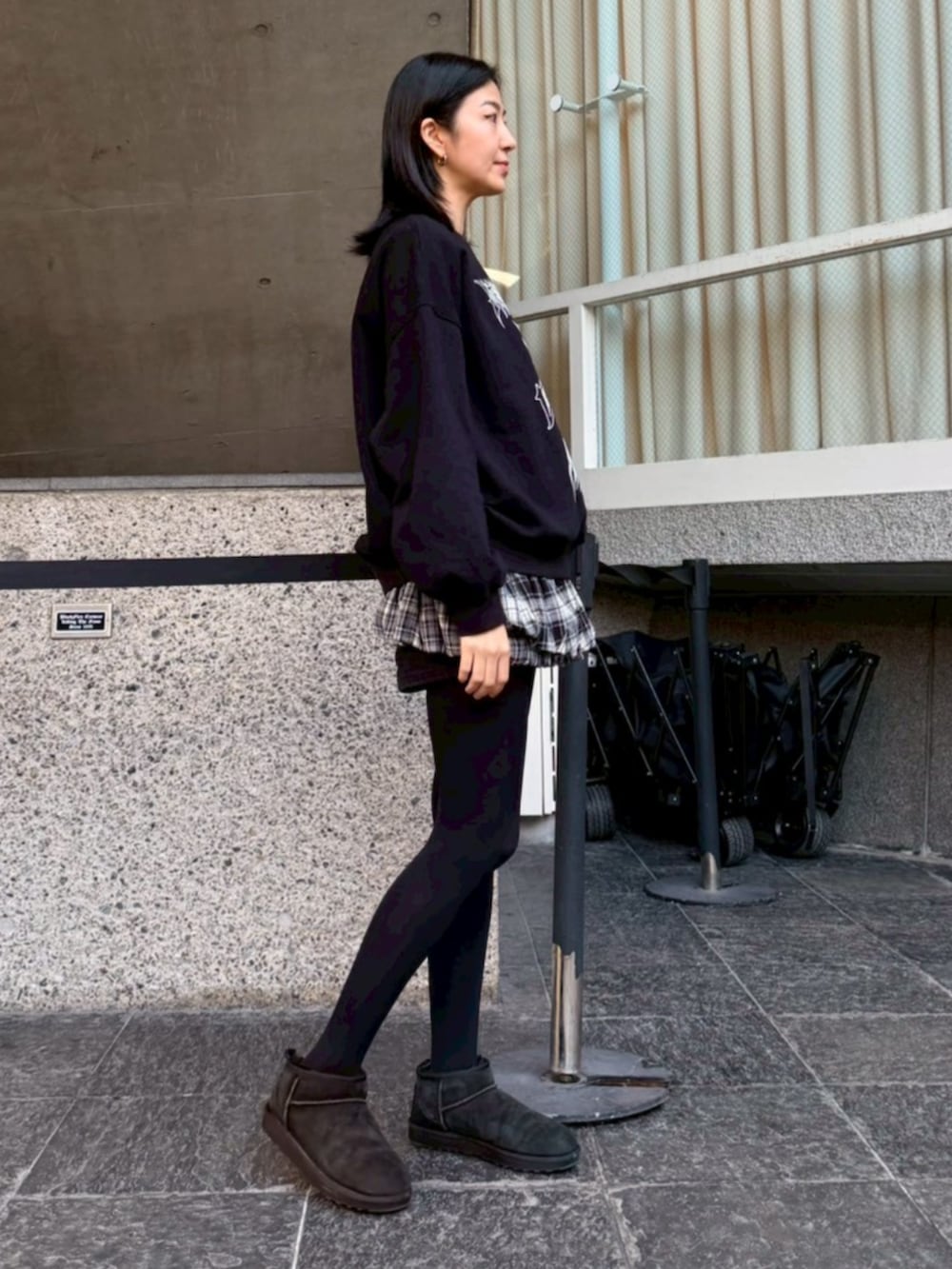 グレー系のスカート、ブラック系のスウェットを着用したレディースの冬コーディネートの2枚目の写真