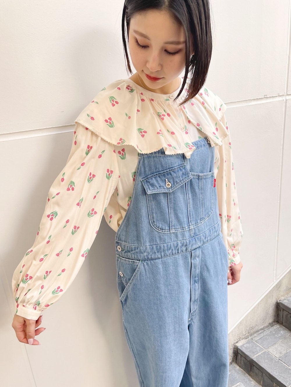 ホワイト系のスニーカー、ブルー系のサロペット/オーバーオール、ホワイト系のシャツ/ブラウスを着用したレディースの春コーディネートの3枚目の写真