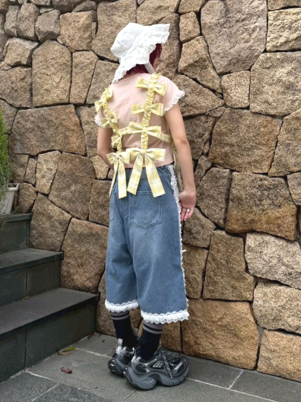 ピンク系のTシャツ/カットソー、イエロー系のその他トップス、ブルー系のデニムパンツを着用したレディースの春コーディネートの3枚目の写真