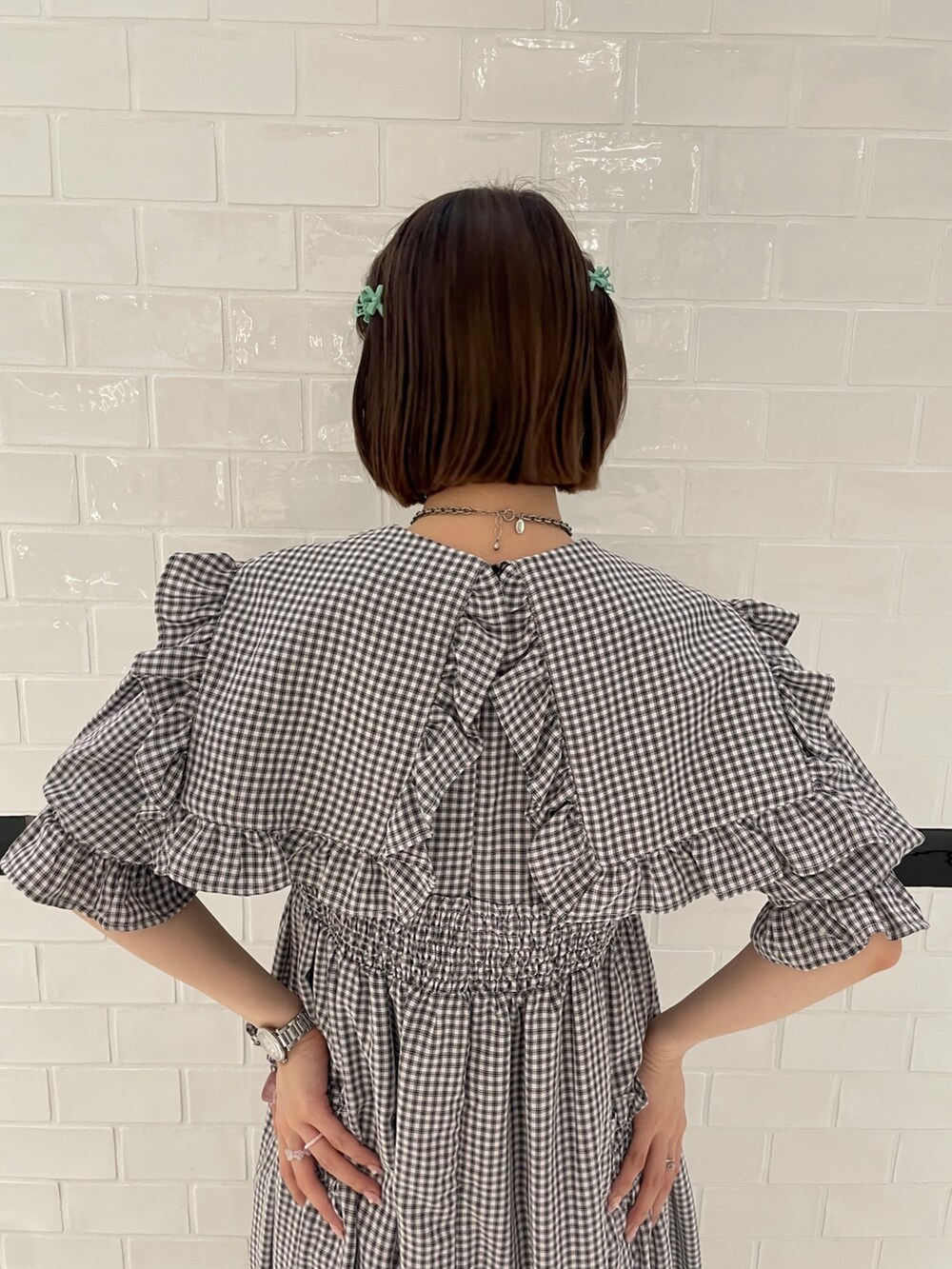 ホワイト系のワンピース、ブラック系のブーツを着用したレディースの春コーディネートの5枚目の写真