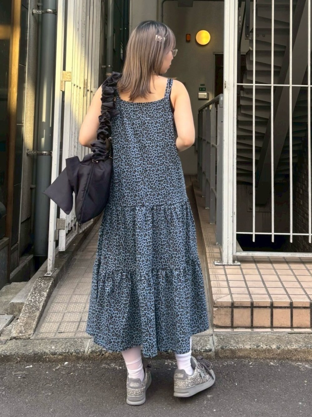 ブラック系のショルダーバッグ、ブラック系のキャミソール、ブルー系のワンピースを着用したレディースの春コーディネートの6枚目の写真