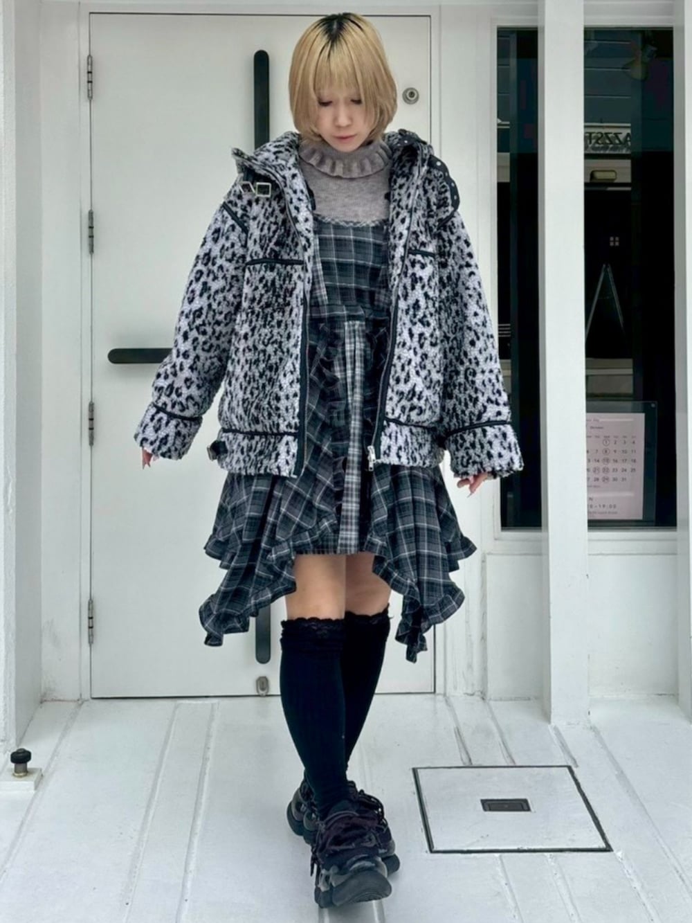 グレー系のダウンジャケット/コート、ブラック系のワンピース、グレー系のニット/セーターを着用したレディースの秋コーディネートの3枚目の写真