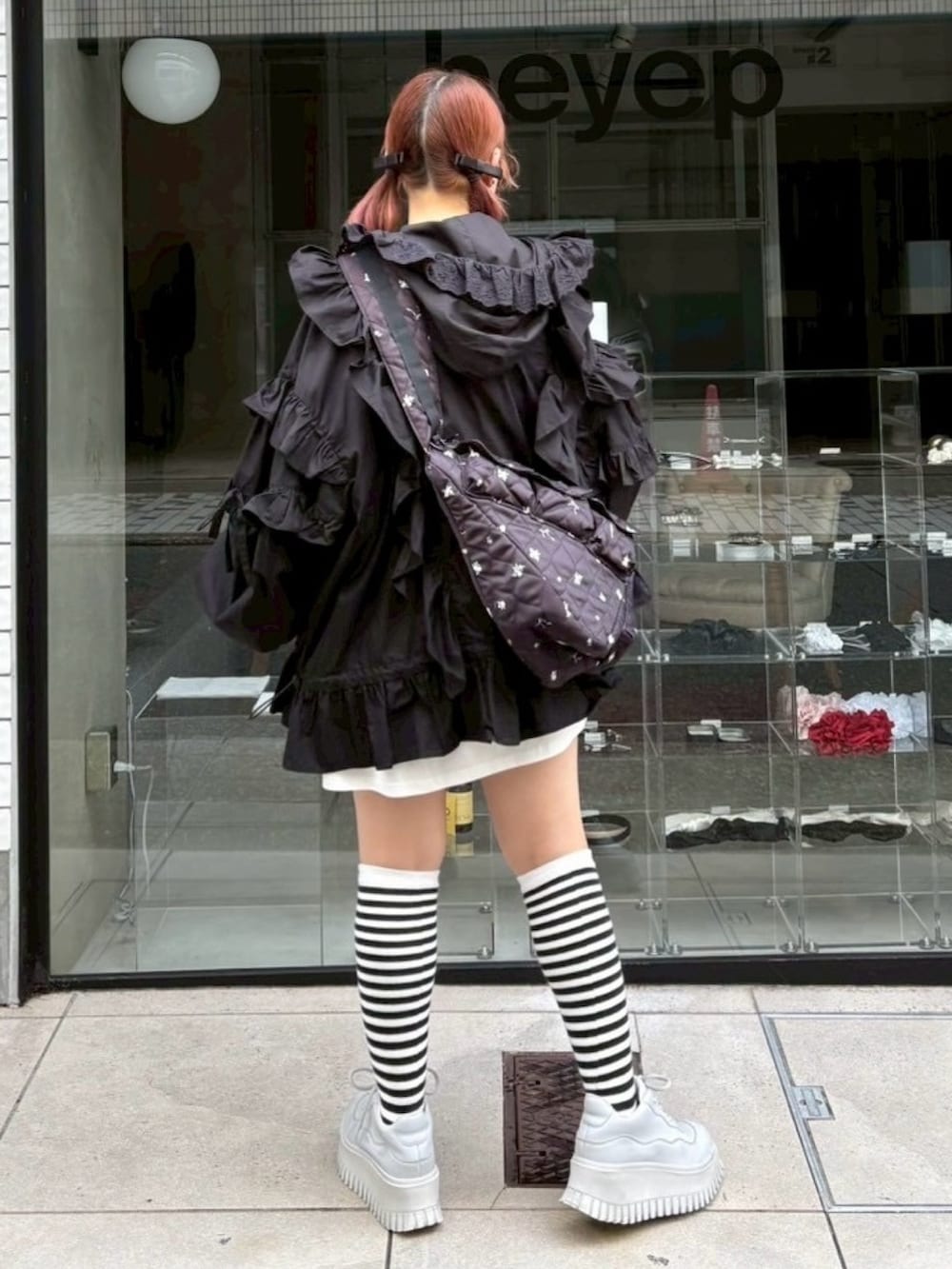 ブラック系のショルダーバッグ、ホワイト系のTシャツ/カットソー、ブラック系のブルゾンを着用したレディースの秋コーディネートの6枚目の写真