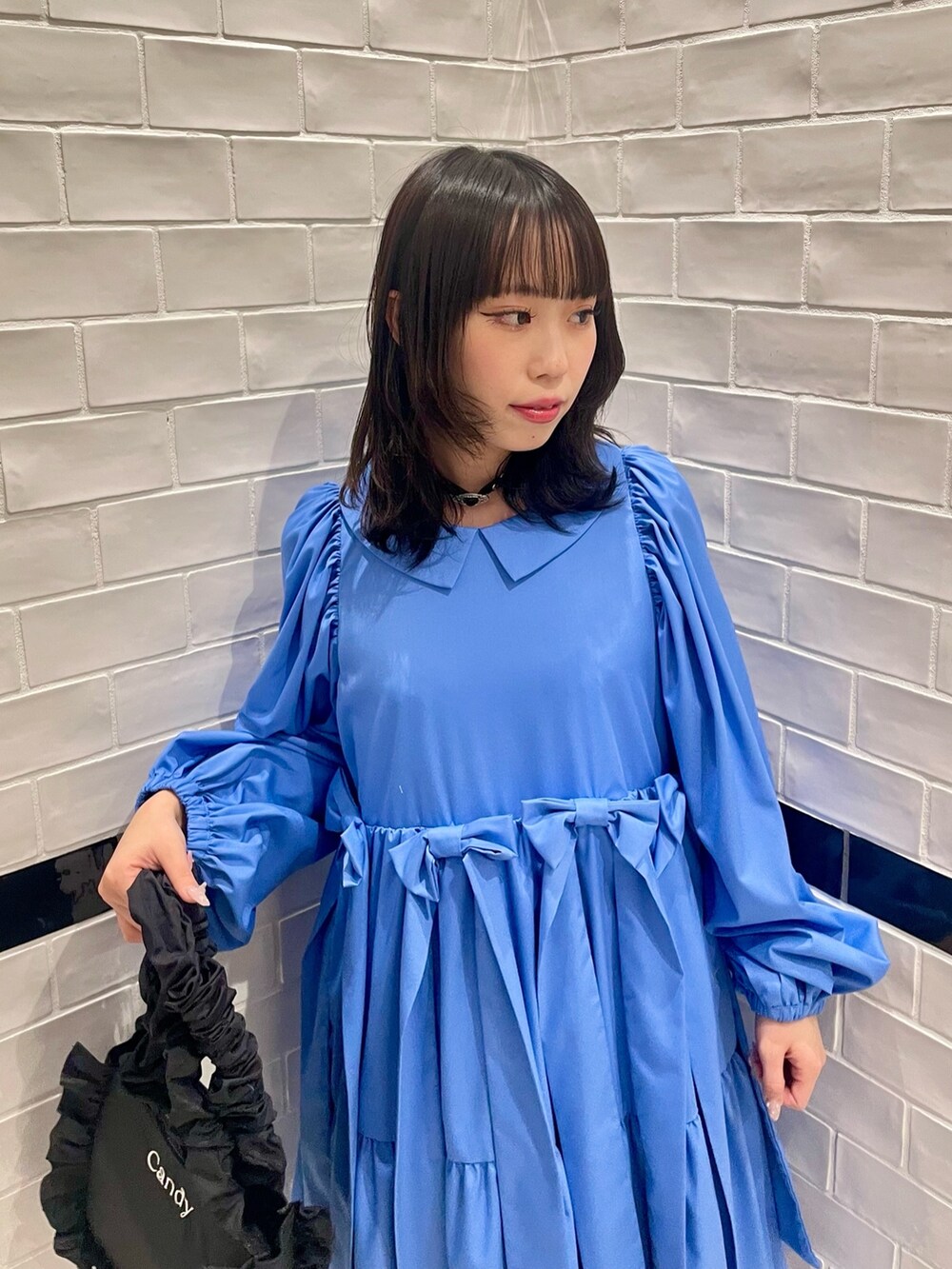 ブラック系のハンドバッグ、ブルー系のワンピース、ホワイト系のソックス/靴下を着用したレディースの冬コーディネートの4枚目の写真