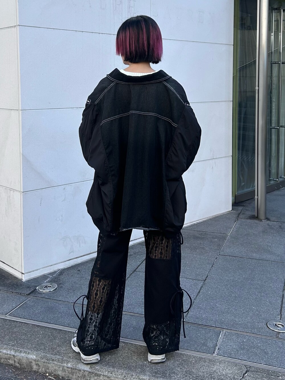 ブラック系のデニムジャケット、ホワイト系のニット/セーター、ブラック系のその他パンツを着用したレディースの冬コーディネートの5枚目の写真