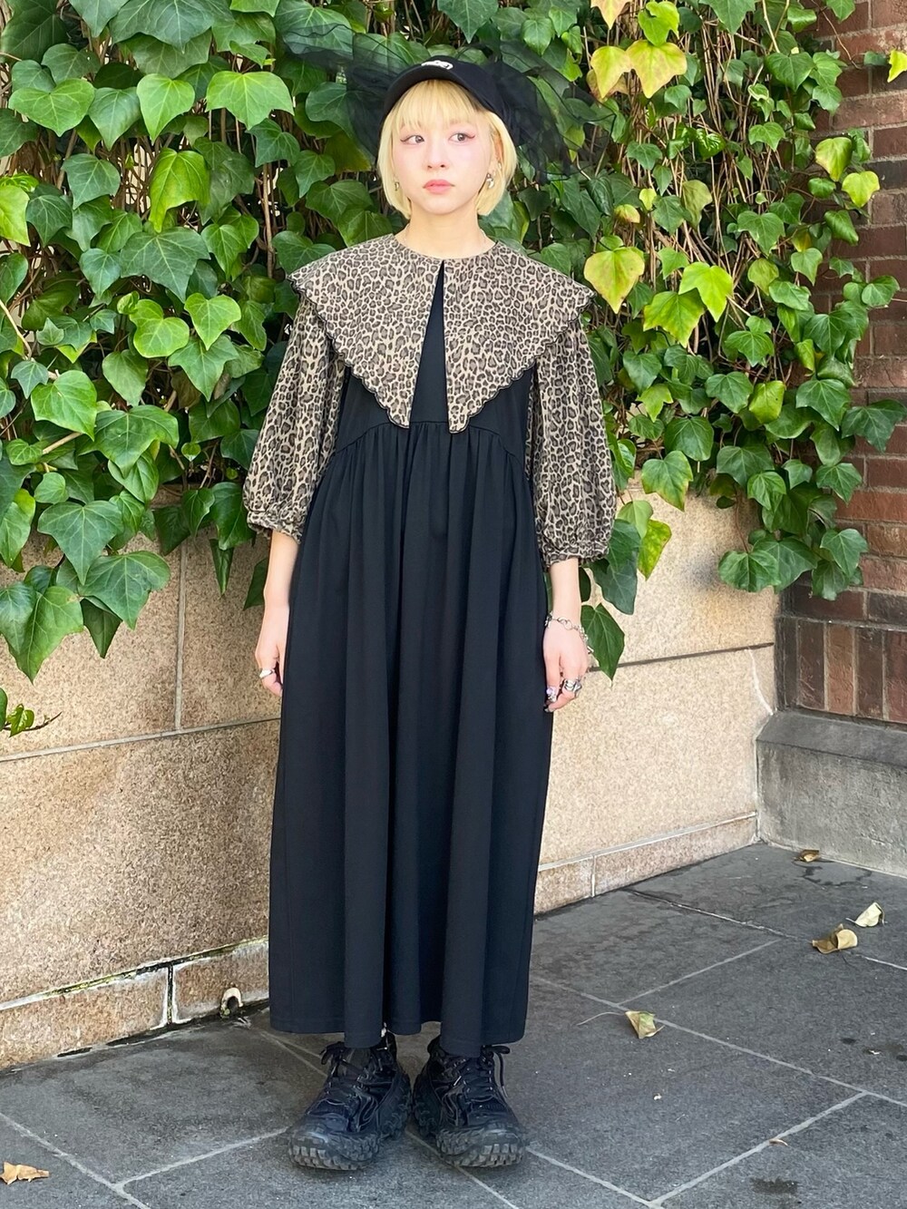 ブラック系のワンピース、ブラック系のキャップを着用したレディースの春コーディネートの2枚目の写真