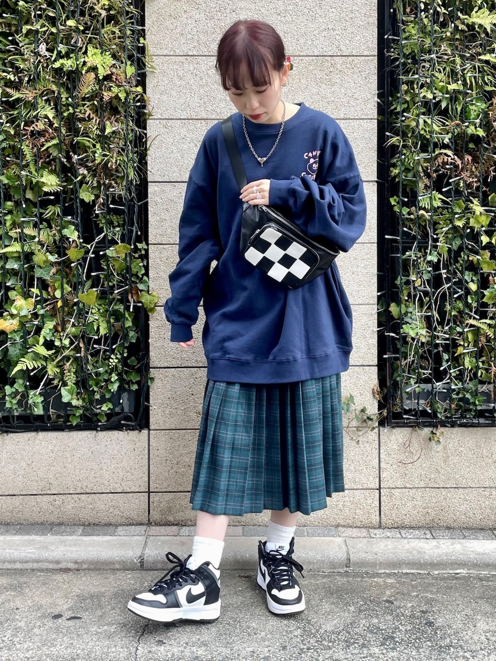 ブルー系のスウェット、グリーン系のスカート、ブラック系のボディバッグ/ウエストポーチを着用したレディースの冬コーディネートの2枚目の写真