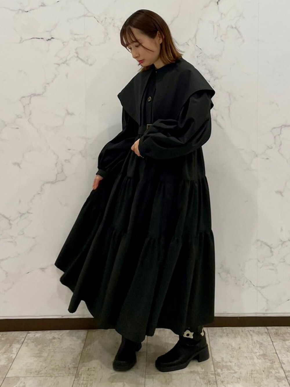 ブラック系のトレンチコート、ブラック系のブーツを着用したレディースの冬コーディネートの3枚目の写真