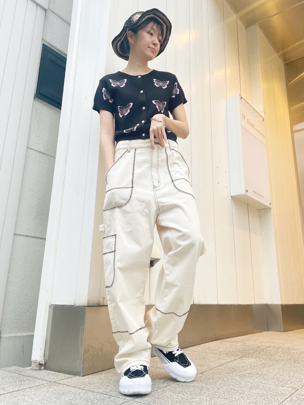 ホワイト系のその他パンツ、ブラック系のカーディガン/ボレロ、ブラック系のスニーカーを着用したレディースの春コーディネートの2枚目の写真