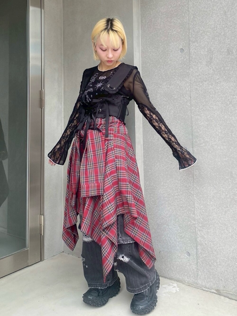 ブラック系のTシャツ/カットソー、ブラック系のその他トップス、レッド系のスカートを着用したレディースの夏コーディネートの3枚目の写真