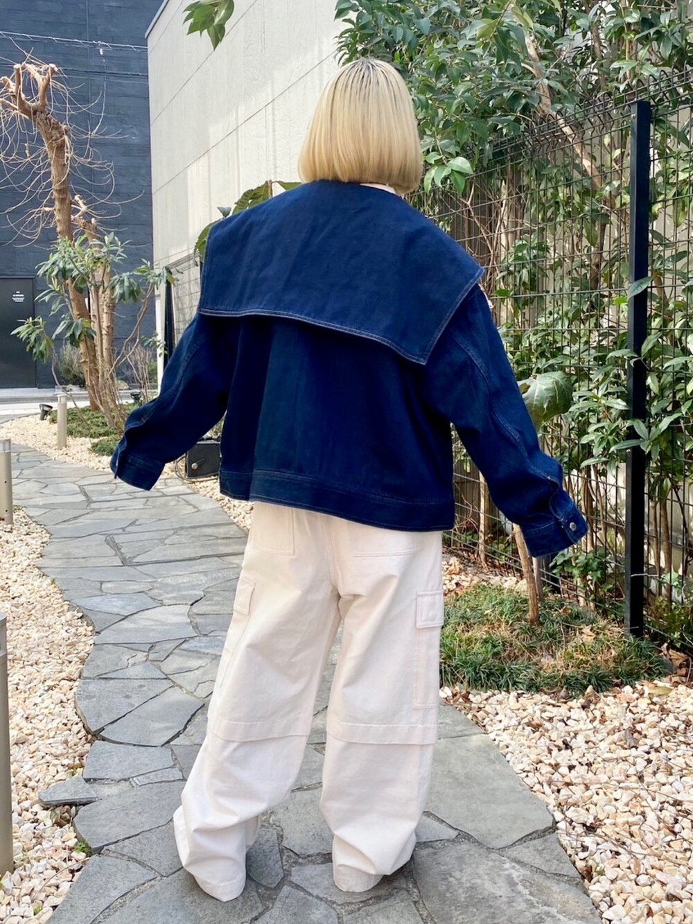 ホワイト系のカーゴパンツ、イエロー系のポロシャツ、ブルー系のデニムジャケットを着用したレディースの春コーディネートの5枚目の写真