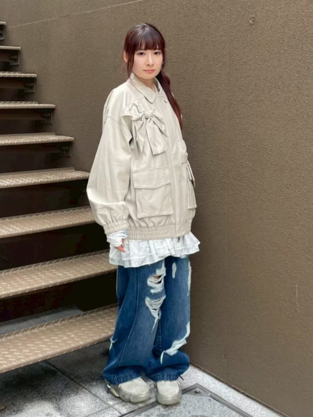 ホワイト系のワンピース、ホワイト系のブルゾン、ブルー系のデニムパンツを着用したレディースの秋コーディネートの2枚目の写真