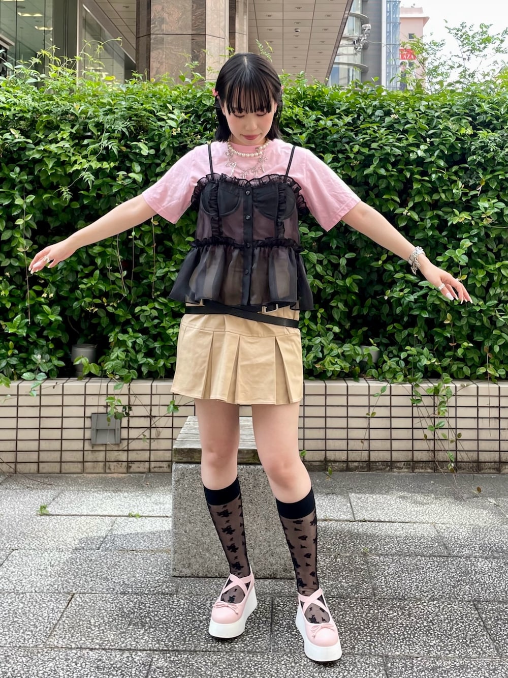 ピンク系のTシャツ/カットソー、ブラック系のキャミソール、ベージュ系のスカートを着用したレディースの春コーディネートの2枚目の写真