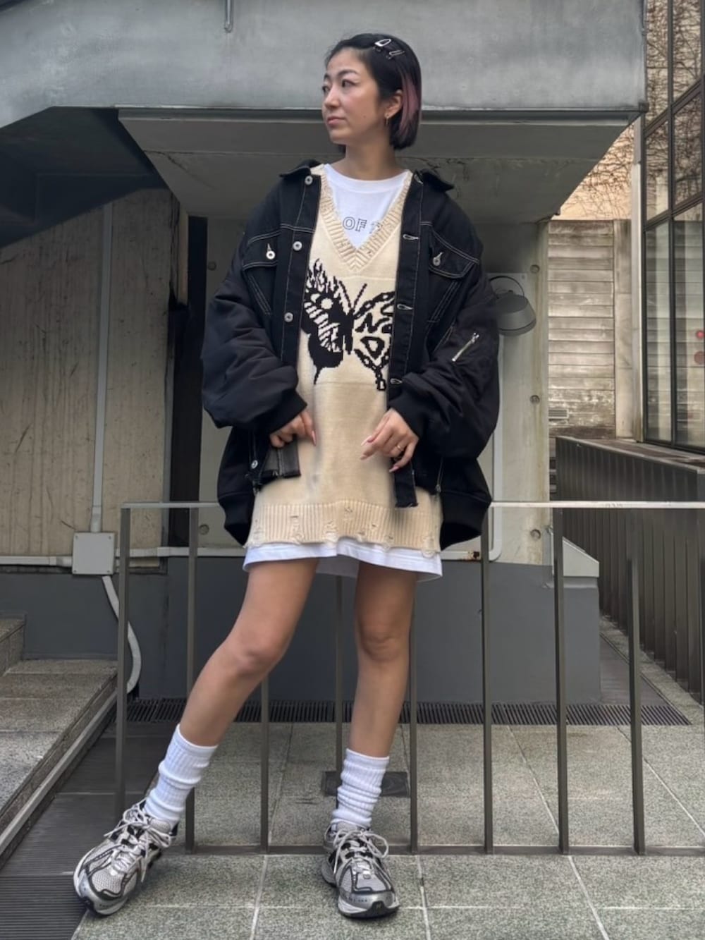 ブラック系のデニムジャケット、ホワイト系のベスト、ホワイト系のTシャツ/カットソーを着用したレディースの冬コーディネートの2枚目の写真