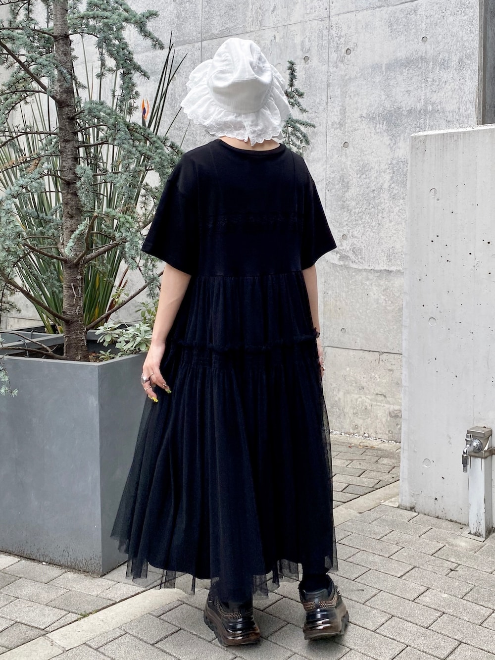 ブラック系のワンピース、ホワイト系のハットを着用したレディースの春コーディネートの4枚目の写真