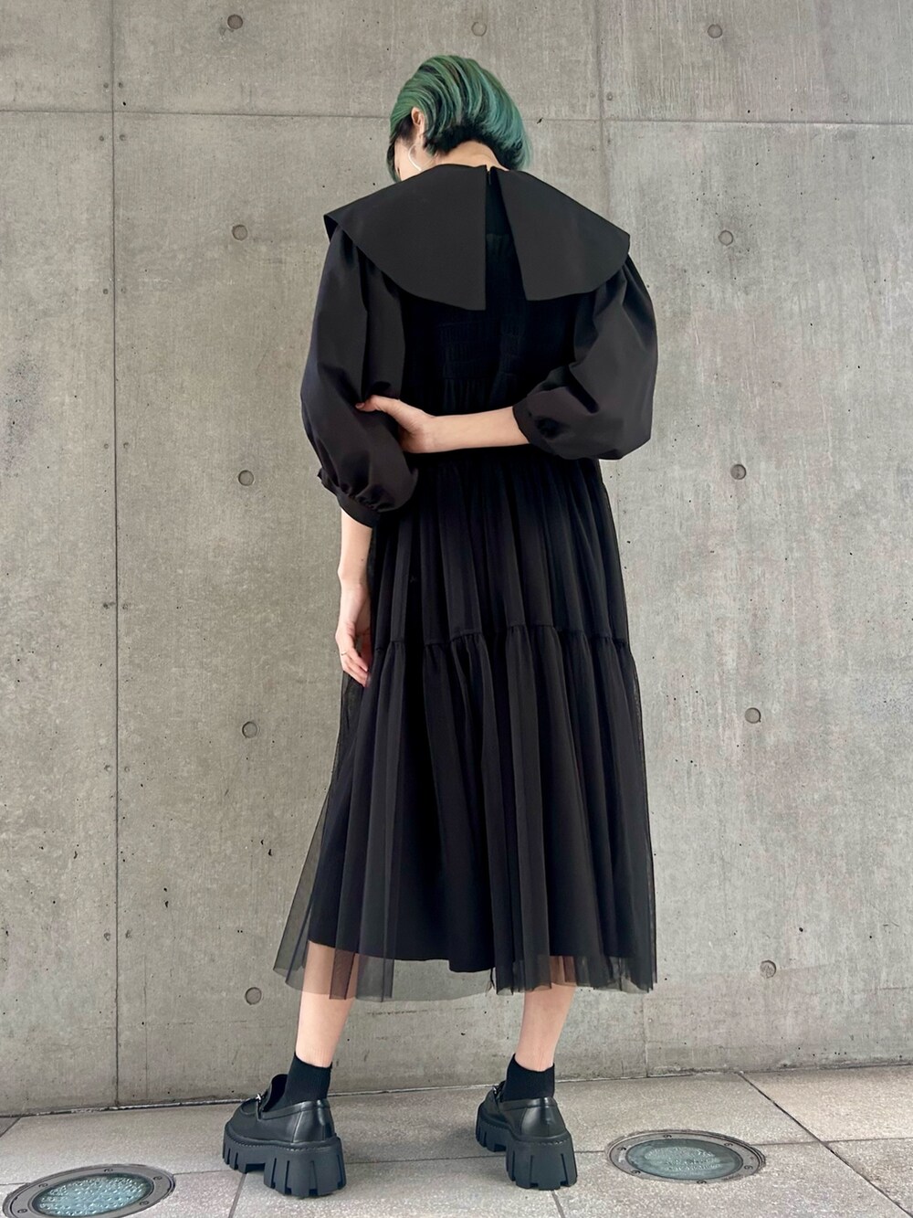 ブラック系のライダースジャケット、ブラック系のワンピース、ブラック系のローファーを着用したレディースの冬コーディネートの6枚目の写真