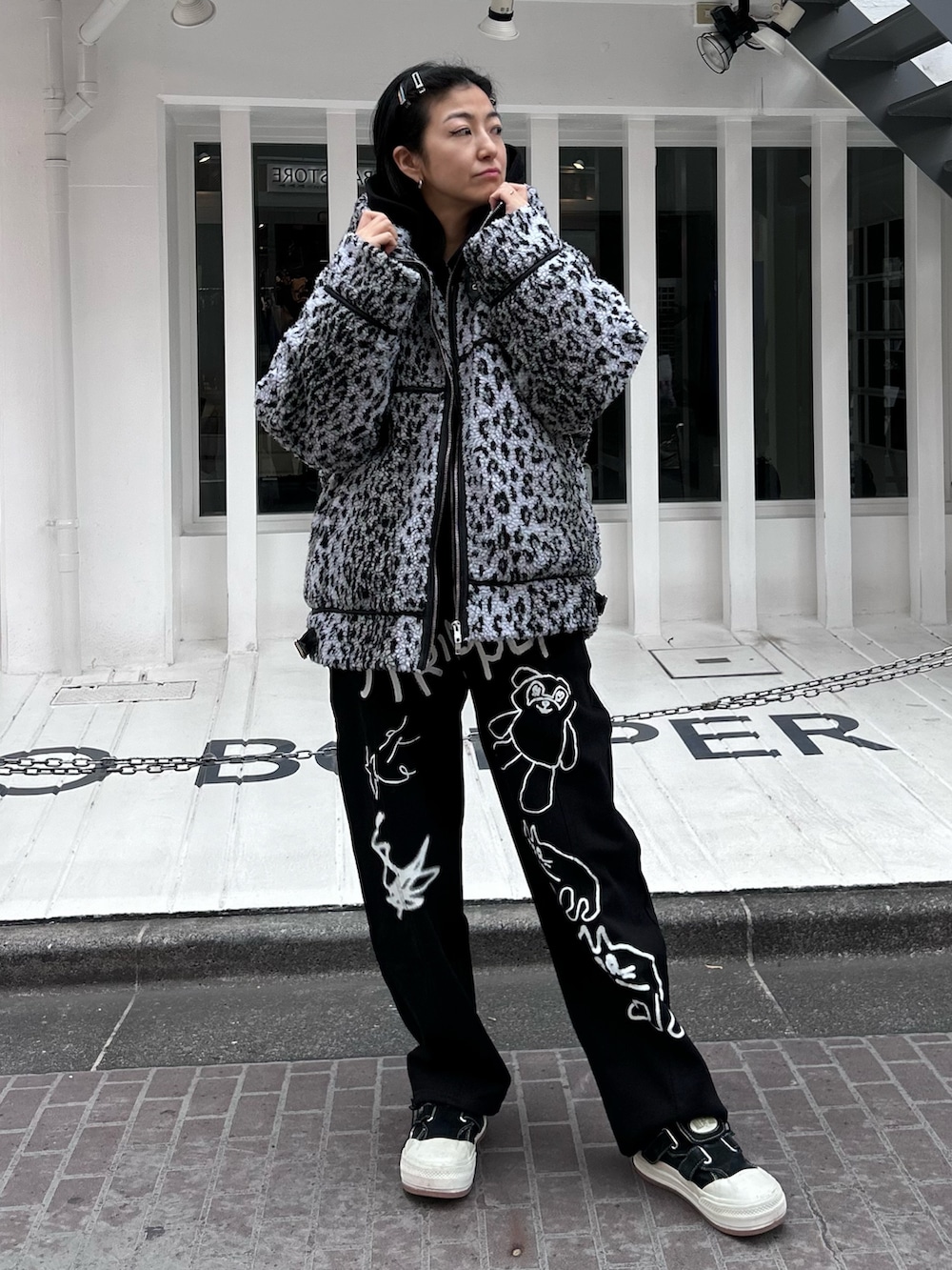 ブラック系のパーカー、グレー系のダウンジャケット/コート、ブラック系のスウェットパンツを着用したレディースの冬コーディネートの4枚目の写真