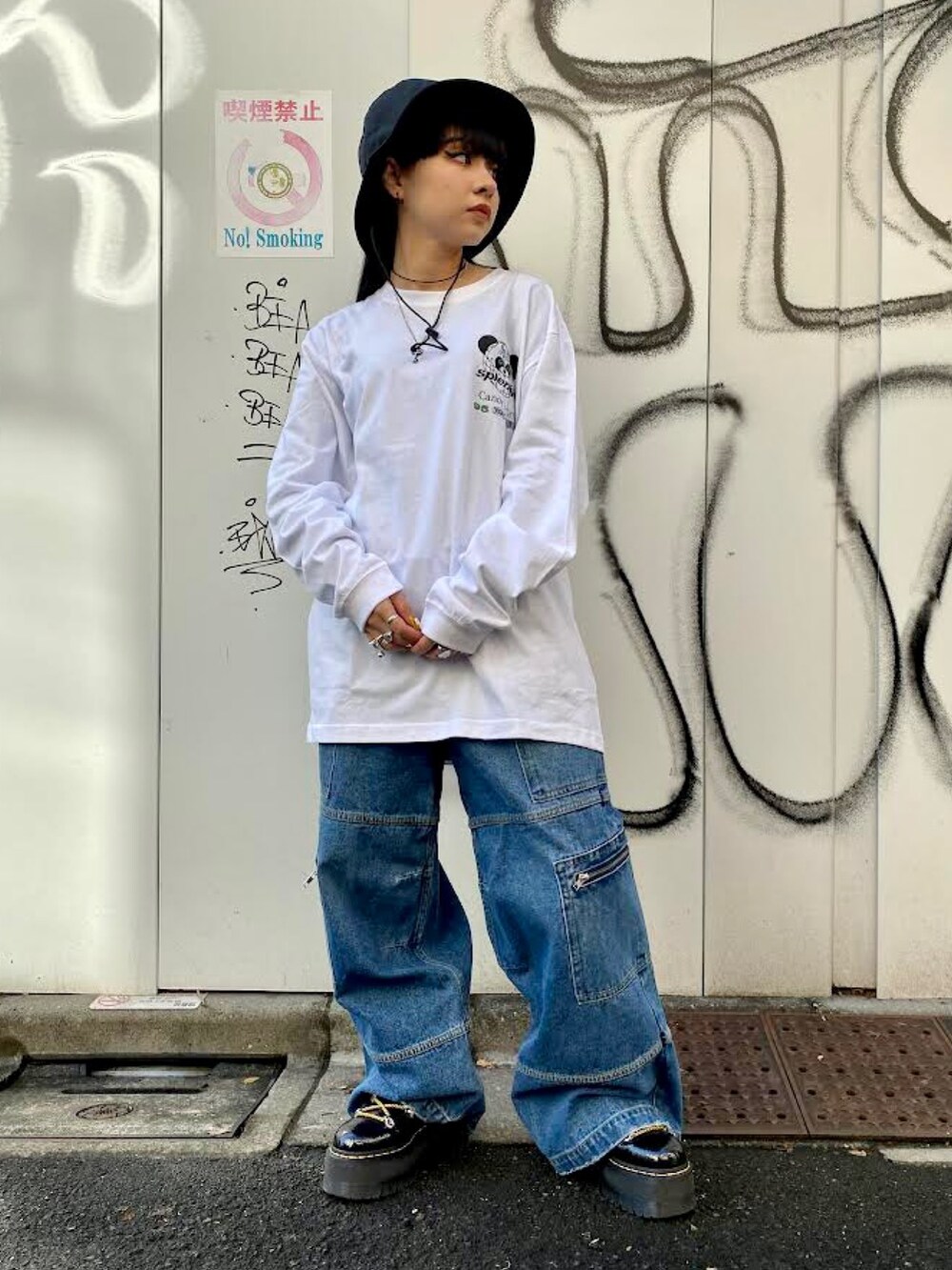 ホワイト系のTシャツ/カットソー、ブルー系のカーゴパンツ、ブラック系のハットを着用したレディースの冬コーディネートの3枚目の写真