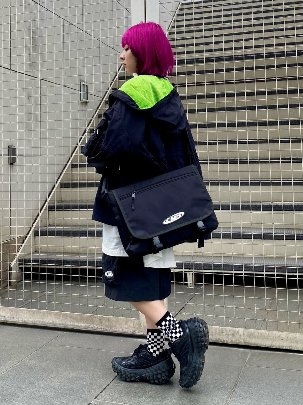 ブラック系のナイロンジャケット、ホワイト系のTシャツ/カットソー、ブラック系のショルダーバッグを着用したレディースの春コーディネートの4枚目の写真