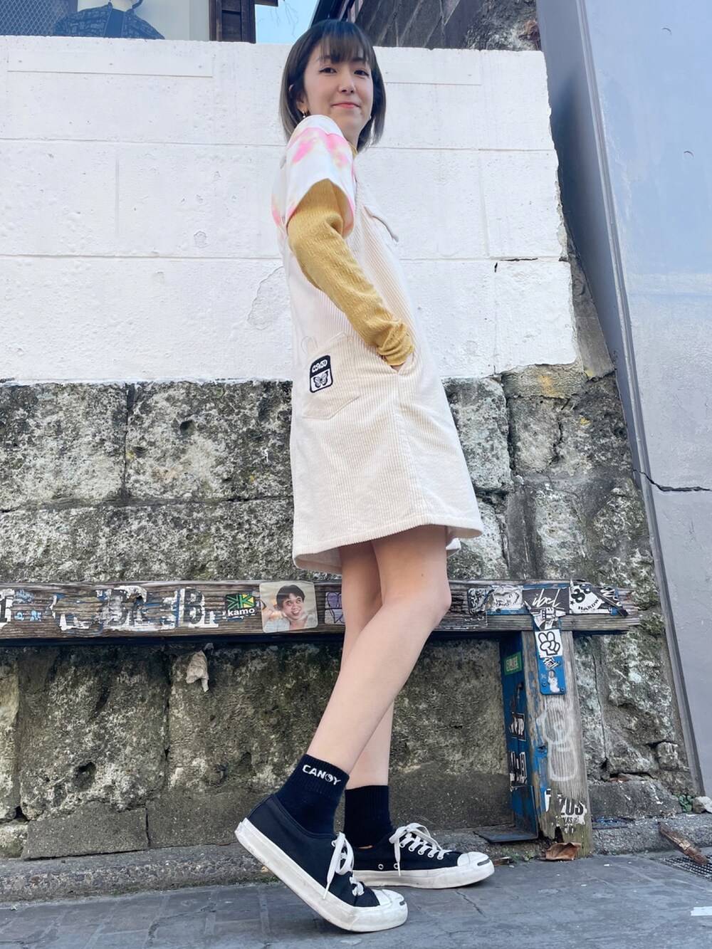 ホワイト系のその他アウター、ホワイト系のジャンパースカート、イエロー系のTシャツ/カットソーを着用したレディースの冬コーディネートの3枚目の写真