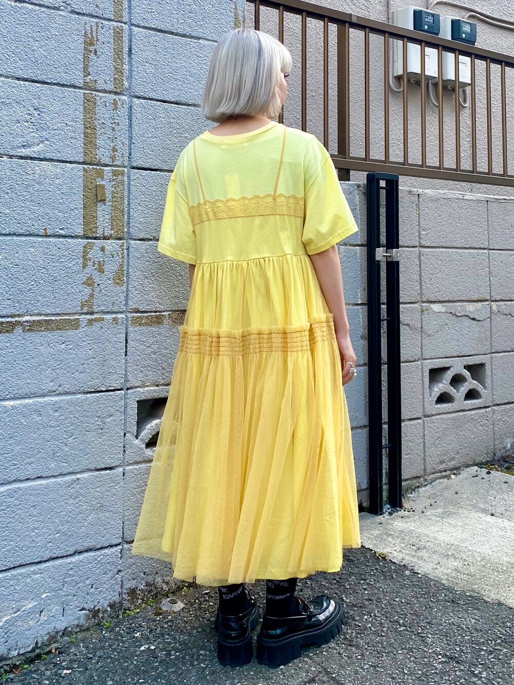 イエロー系のワンピース、ブラック系のローファーを着用したレディースの夏コーディネートの4枚目の写真
