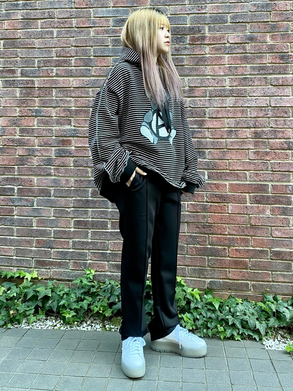 ブラック系のパーカー、ブラック系のその他パンツを着用したレディースの冬コーディネートの2枚目の写真