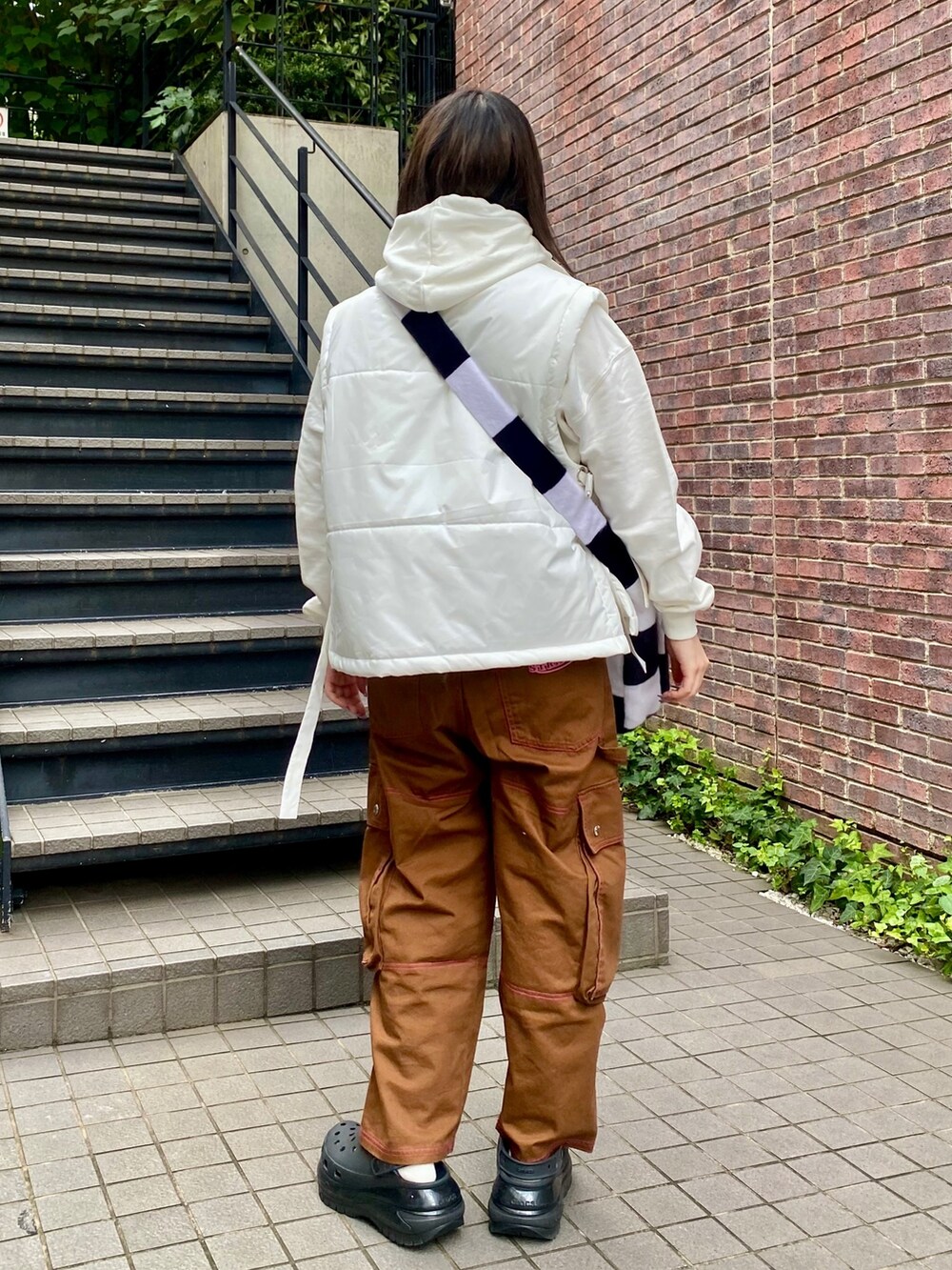 ホワイト系のショルダーバッグ、ブラウン系のカーゴパンツ、ホワイト系のパーカーを着用したレディースの秋コーディネートの4枚目の写真