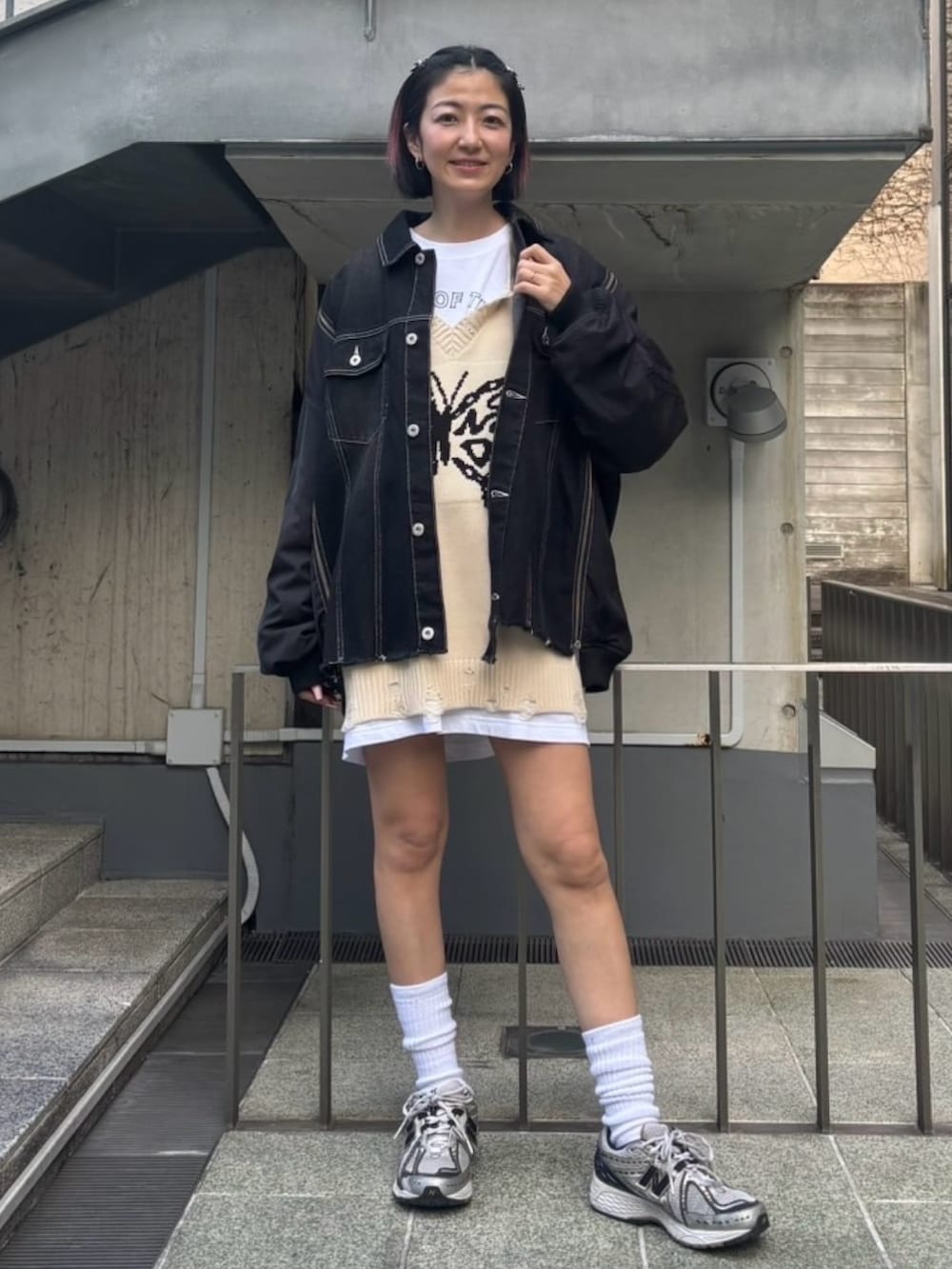 ブラック系のデニムジャケット、ホワイト系のベスト、ホワイト系のTシャツ/カットソーを着用したレディースの冬コーディネートの3枚目の写真