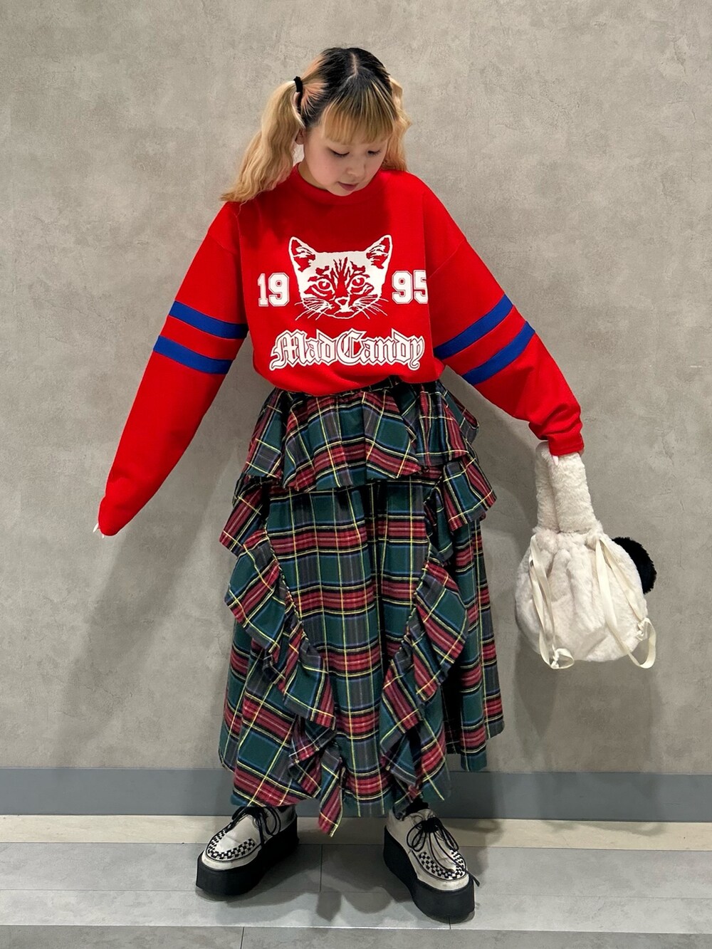 ホワイト系のハンドバッグ、グリーン系のスカート、レッド系のTシャツ/カットソーを着用したレディースの秋コーディネートの2枚目の写真