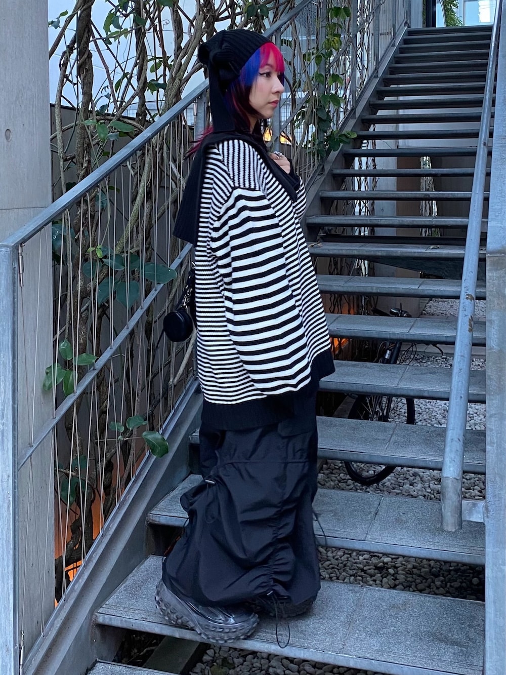 ブラック系のスカート、ブラック系のショルダーバッグ、ブラック系のニット/セーターを着用したレディースの冬コーディネートの4枚目の写真