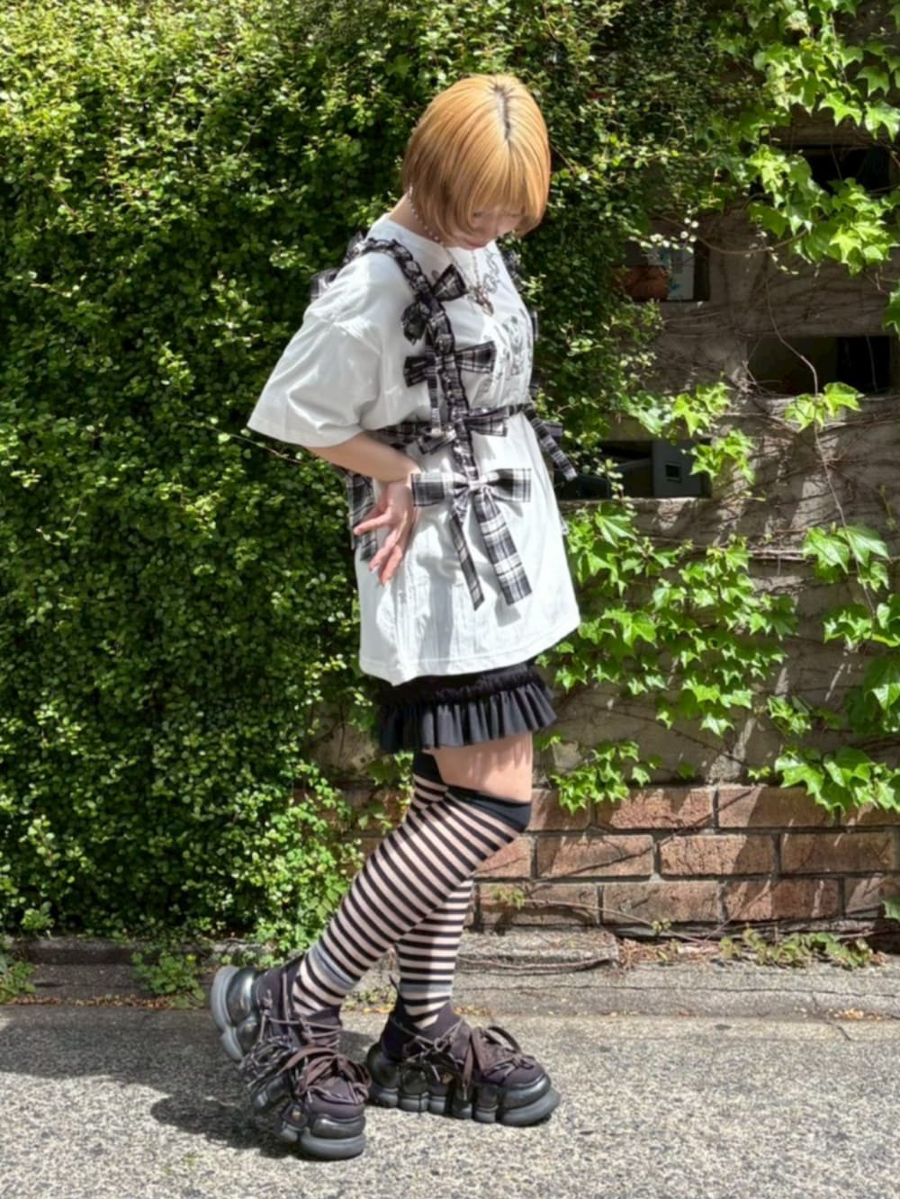 ブラック系のその他トップス、ブラック系のその他パンツ、ホワイト系のTシャツ/カットソーを着用したレディースの春コーディネートの2枚目の写真