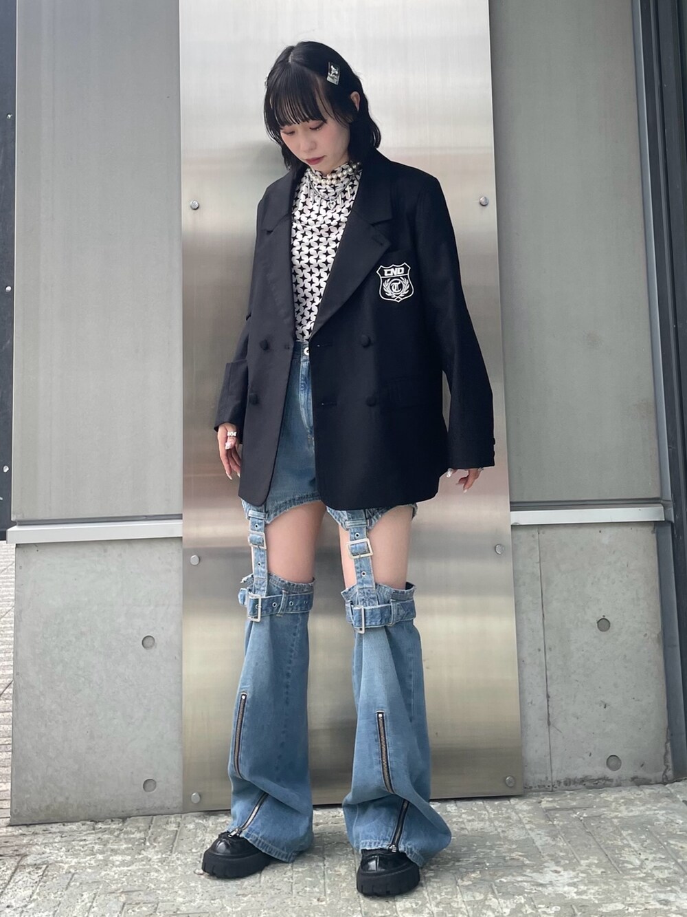 ブラック系のテーラードジャケット、ホワイト系のその他トップス、ブルー系のデニムパンツを着用したレディースの秋コーディネートの2枚目の写真