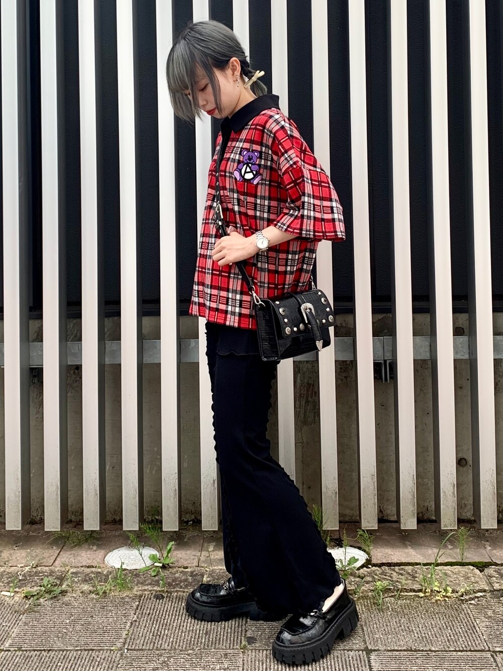 ブラック系のショルダーバッグ、レッド系のポロシャツ、ブラック系のその他パンツを着用したレディースの夏コーディネートの2枚目の写真