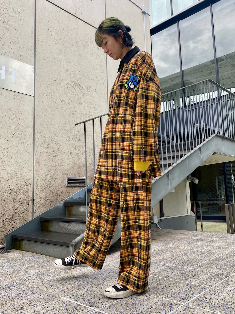 イエロー系のポロシャツ、イエロー系のその他パンツ、ブラック系のスニーカーを着用したレディースの秋コーディネートの3枚目の写真