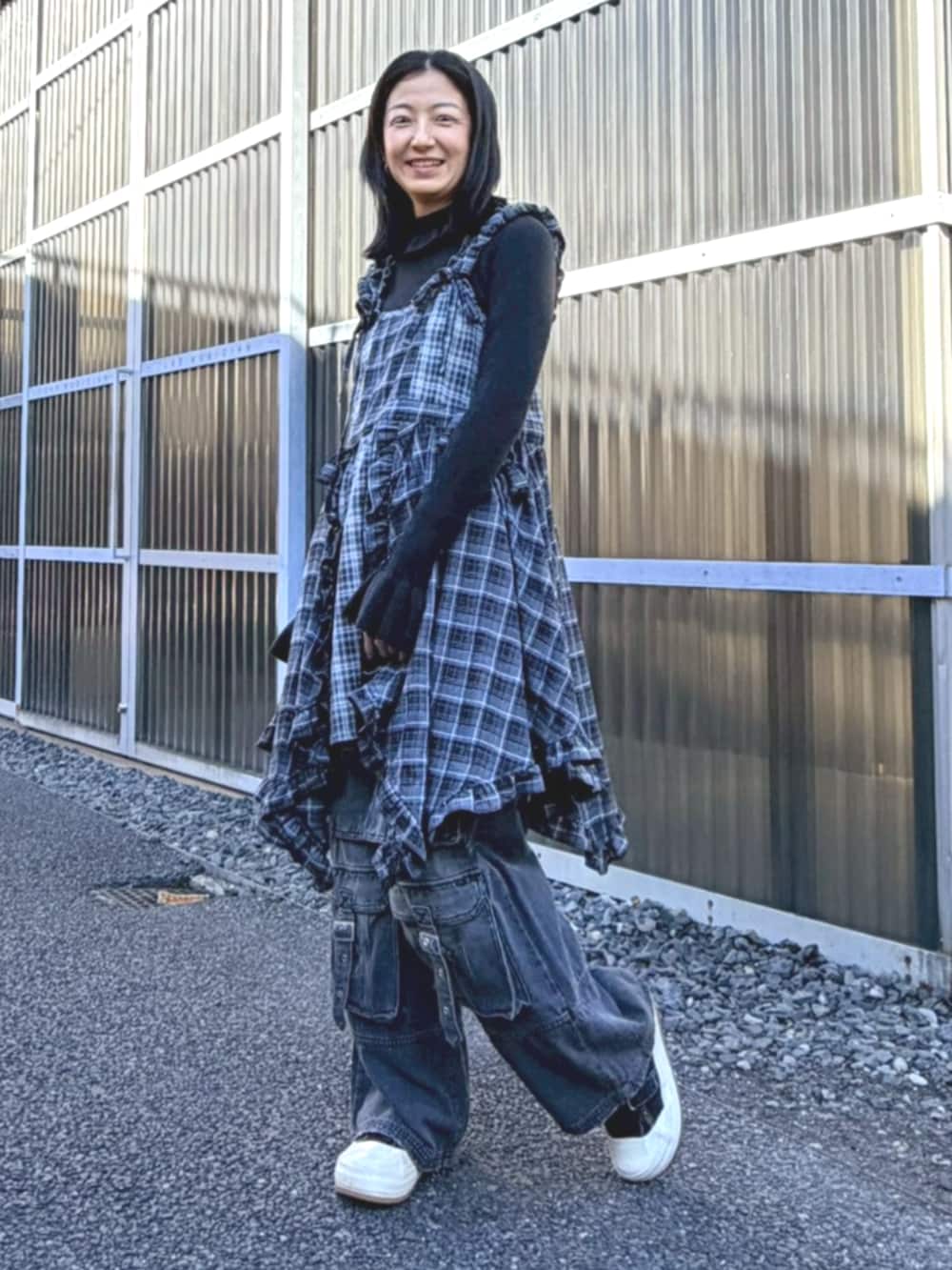 ブラック系のデニムパンツ、ブラック系のワンピース、ブラック系のニット/セーターを着用したレディースの冬コーディネートの3枚目の写真