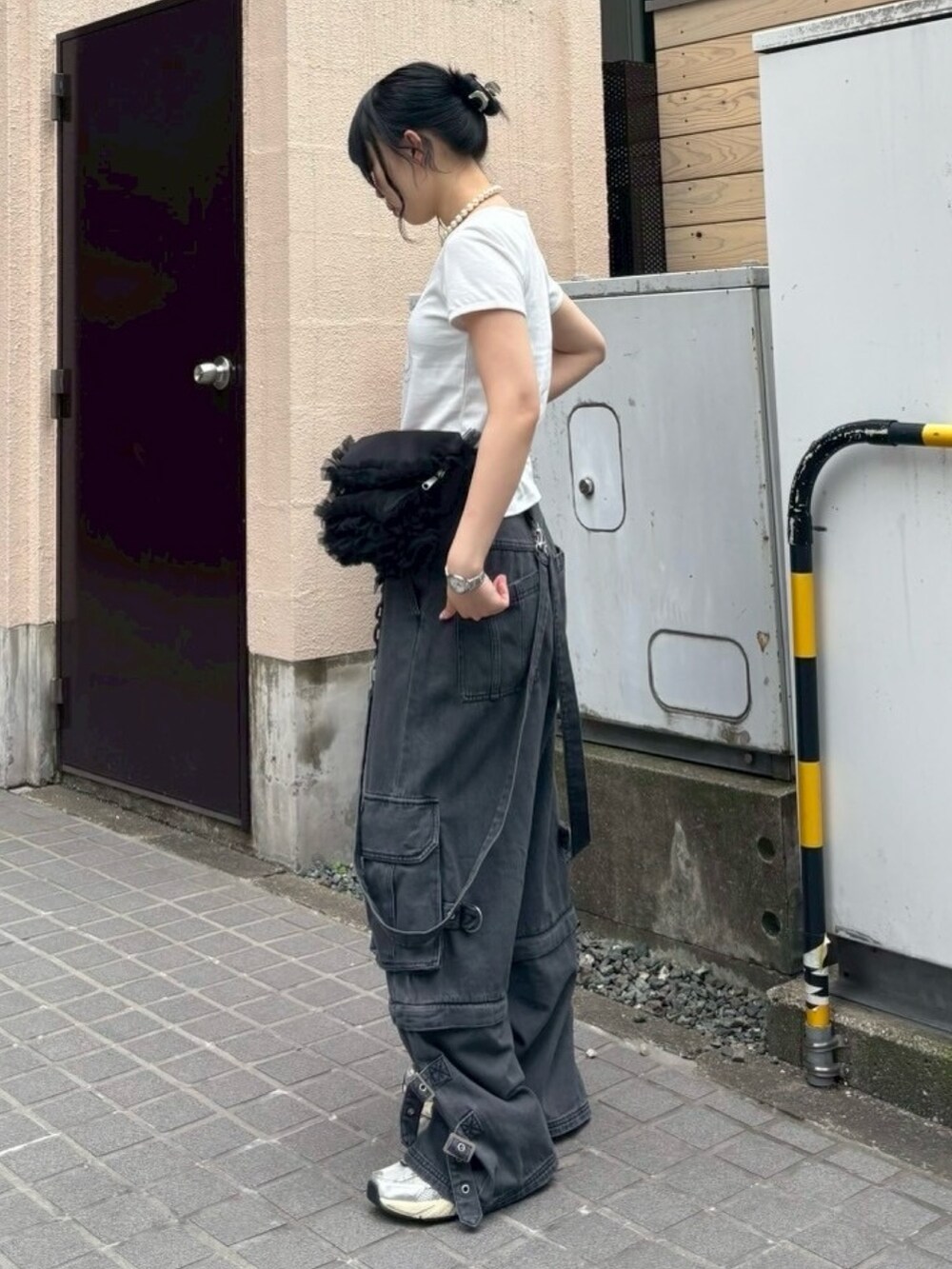 ブラック系のボディバッグ/ウエストポーチ、ブラック系のデニムパンツ、ホワイト系のTシャツ/カットソーを着用したレディースの夏コーディネートの2枚目の写真