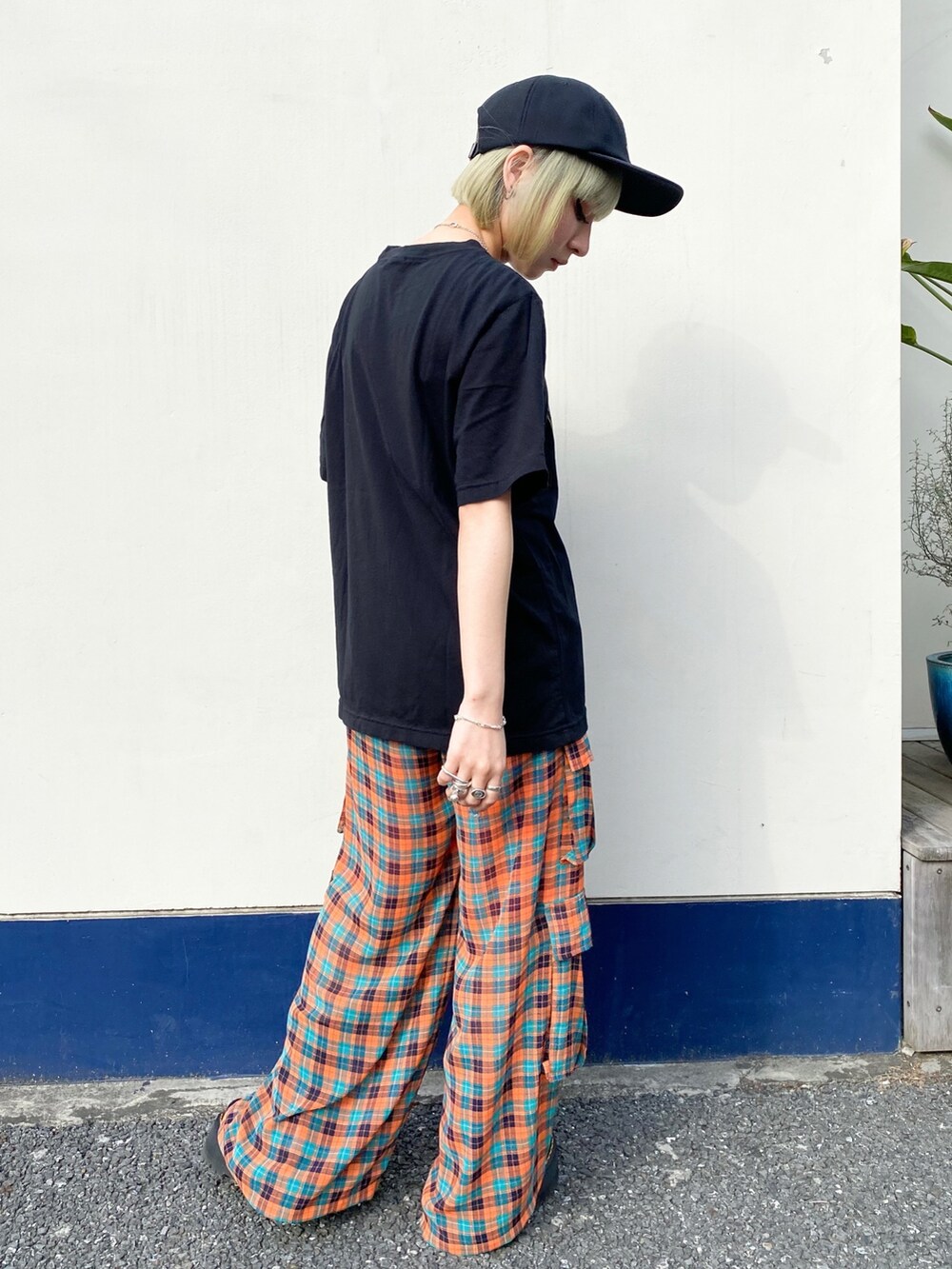 ブラック系のTシャツ/カットソー、オレンジ系のその他パンツ、ブラック系のシューズを着用したレディースの春コーディネートの2枚目の写真