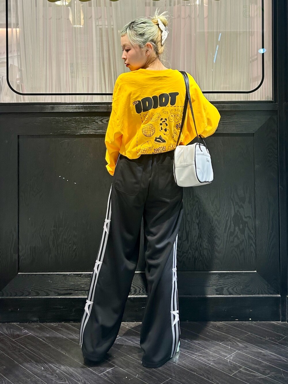 ブラック系のその他パンツ、イエロー系のTシャツ/カットソー、ホワイト系のボストンバッグを着用したレディースの冬コーディネートの3枚目の写真