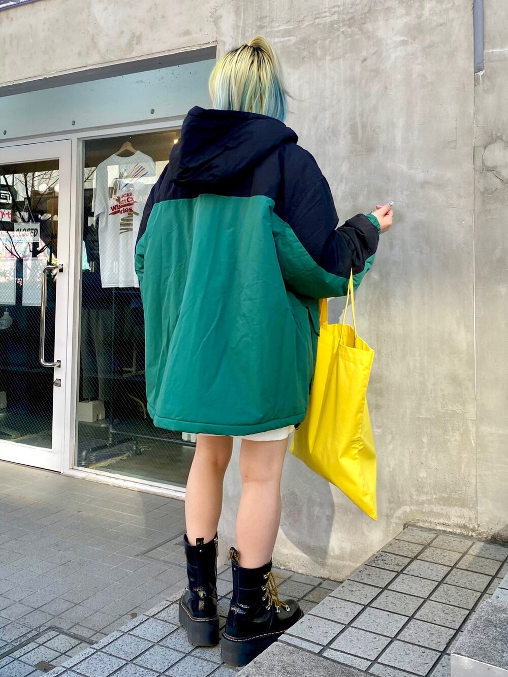 ブラック系のダウンジャケット/コート、ホワイト系のスウェット、イエロー系のトートバッグを着用したレディースの冬コーディネートの4枚目の写真