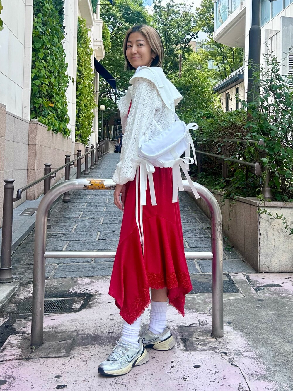 ホワイト系のカーディガン/ボレロ、レッド系のワンピース、ホワイト系のボディバッグ/ウエストポーチを着用したレディースの夏コーディネートの3枚目の写真